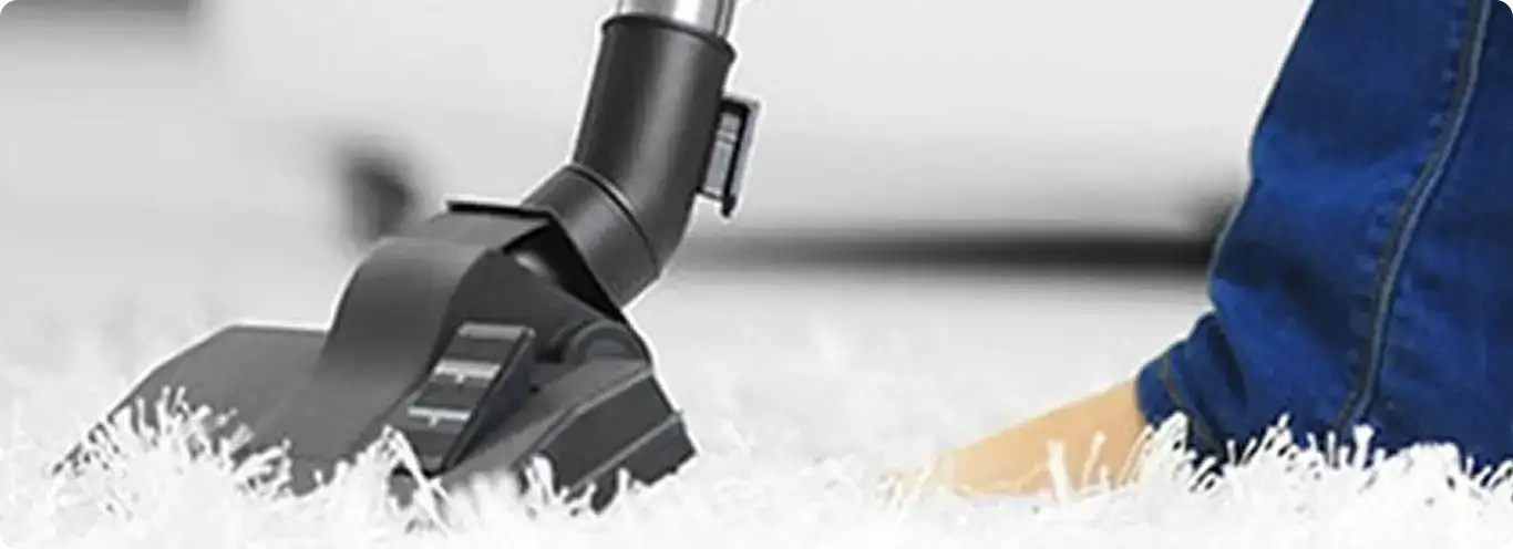 Close-up of a professional vacuuming a white carpet in Viola.
